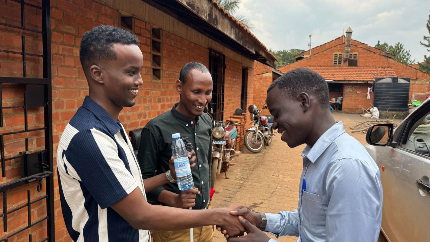 Photo of Abdirahman Mohamud Kulane and Abdulkadir Mohamed Abdullahi interacts with a visually impaired student at KyU Hi-Techn Center in Kampala, Uganda.