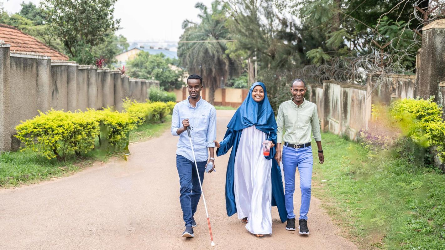 A photo of the UDHAN team strolling along a street in Kampala.