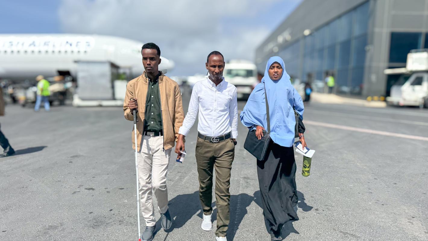 A photo of Abdirahman Mohamud Kulane (left), Abdulkadir Mohamed Abdullahi (middle), and Hamdi Hussein Osman (right), prepare to departure from Adan Adde airport on their way to kampala to participate in a week-long training on braille production and digital inclusion.