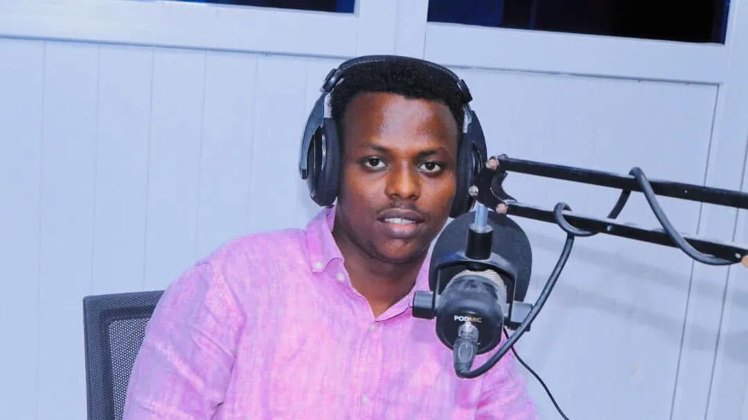 Abdishakur Abdirahman in front of a microphone wearing headphones Abdishakur Abdirahman in front of a microphone wearing headphones