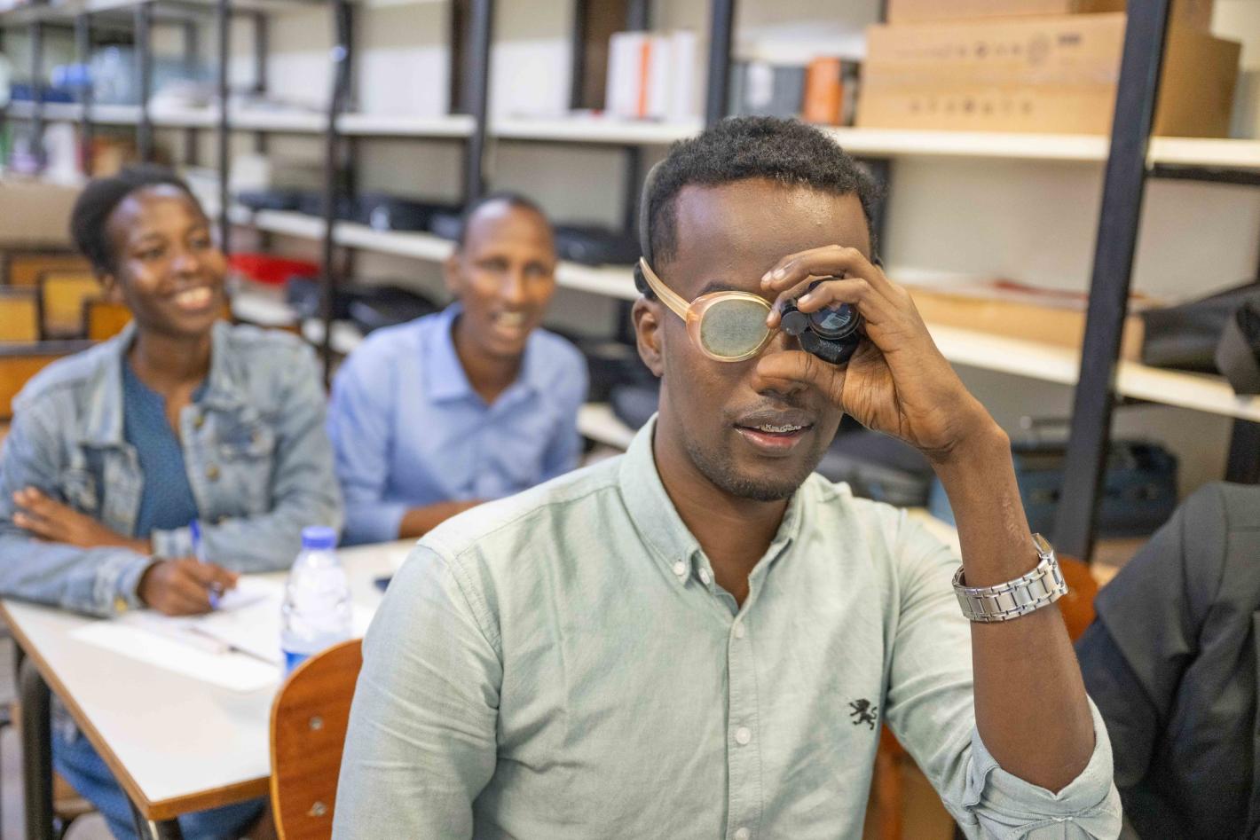 Photo of Mr. Kulane tries on a pair of low-vision glasses for the first time.