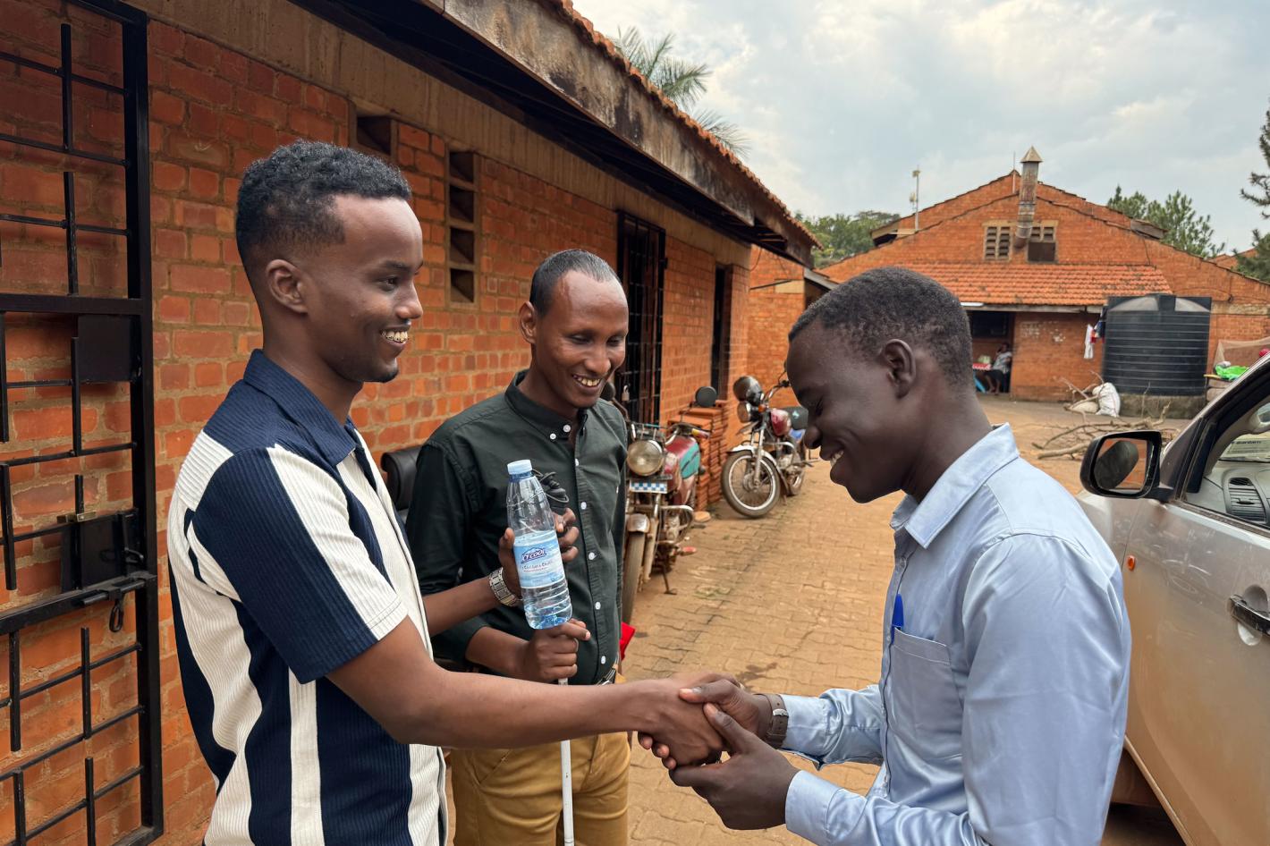 Photo of Abdirahman Mohamud Kulane and Abdulkadir Mohamed Abdullahi interacts with a visually impaired student at KyU Hi-Techn Center in Kampala, Uganda.