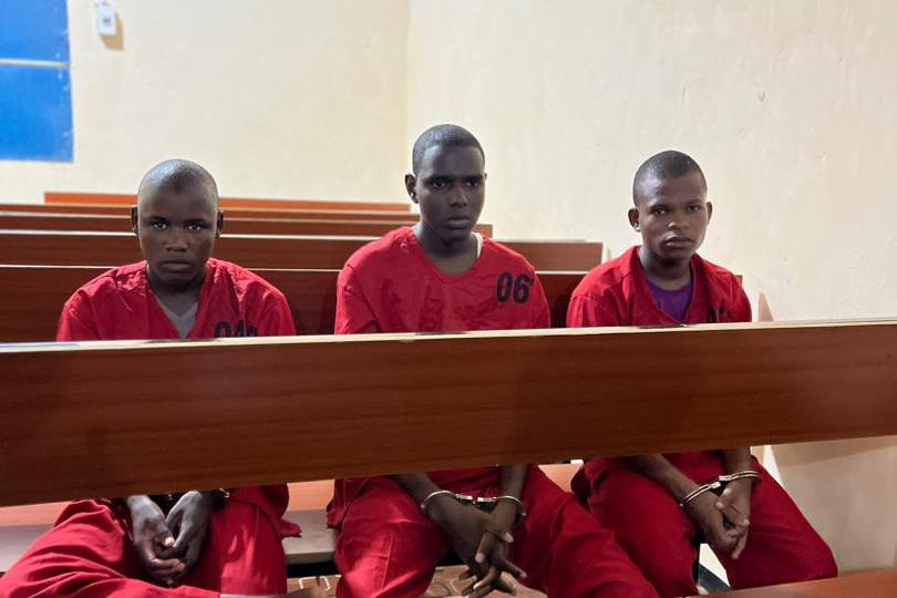 Three boys being sitting in a court room