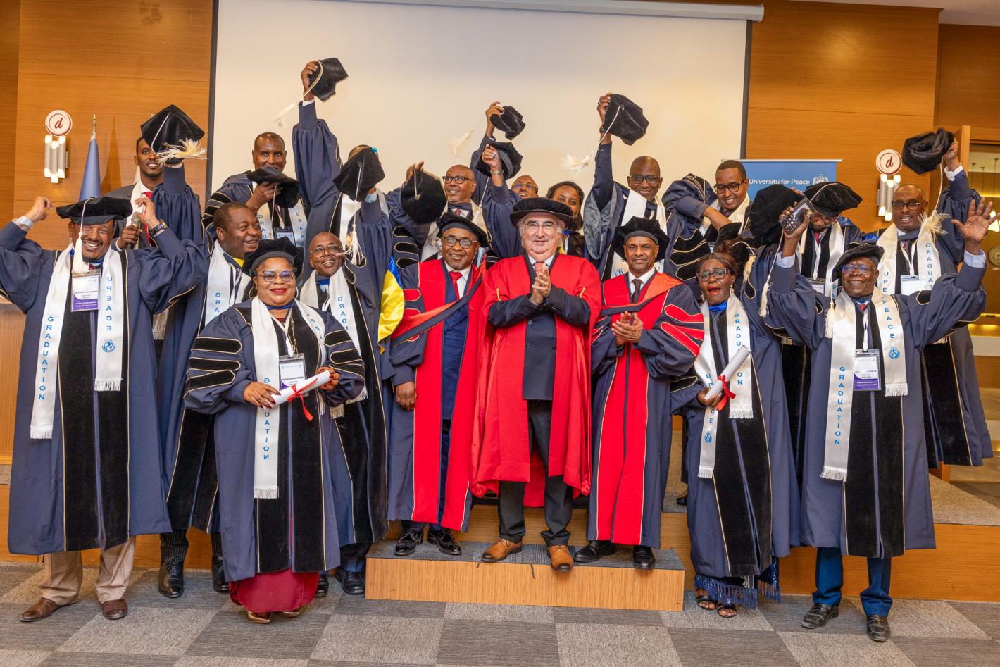 A group of graduates raise their mortarboards with UPEACE senior officials at the fourth UPEACE graduation ceremony held in Mogadishu, Somalia, on 24 January 2025.