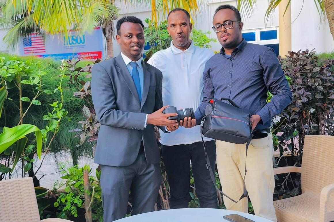 Abdishakur Abdirahman receives camera after signing with BBC Media Climate
