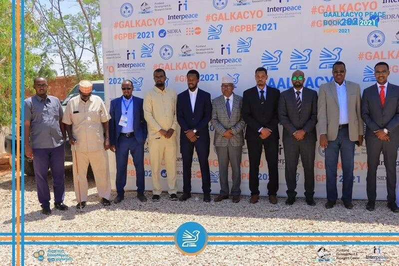 Group of men in front of a backdrop of the Galkacyo Peace Forum 2021 Group of men in front of a backdrop of the Galkacyo Peace Forum 2021